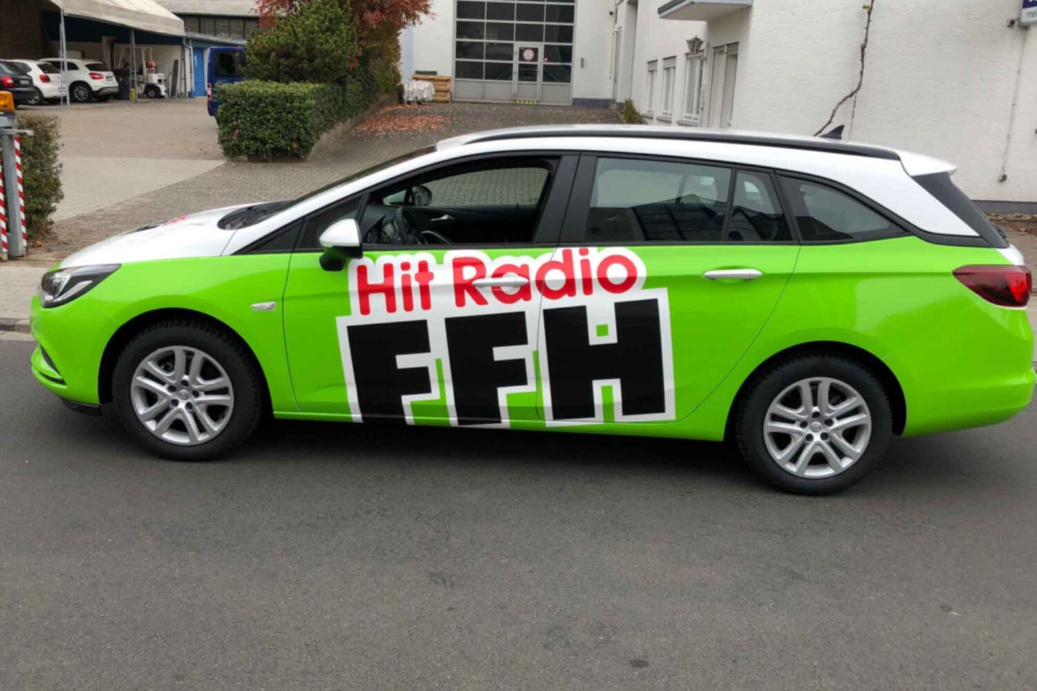 Vollverklebung-FFH Fahrzeugbeschriftung für Hit Radio FFH Vollverklebung in Grün mit Plotts Auto vor unserer Halle in Dietzenbach