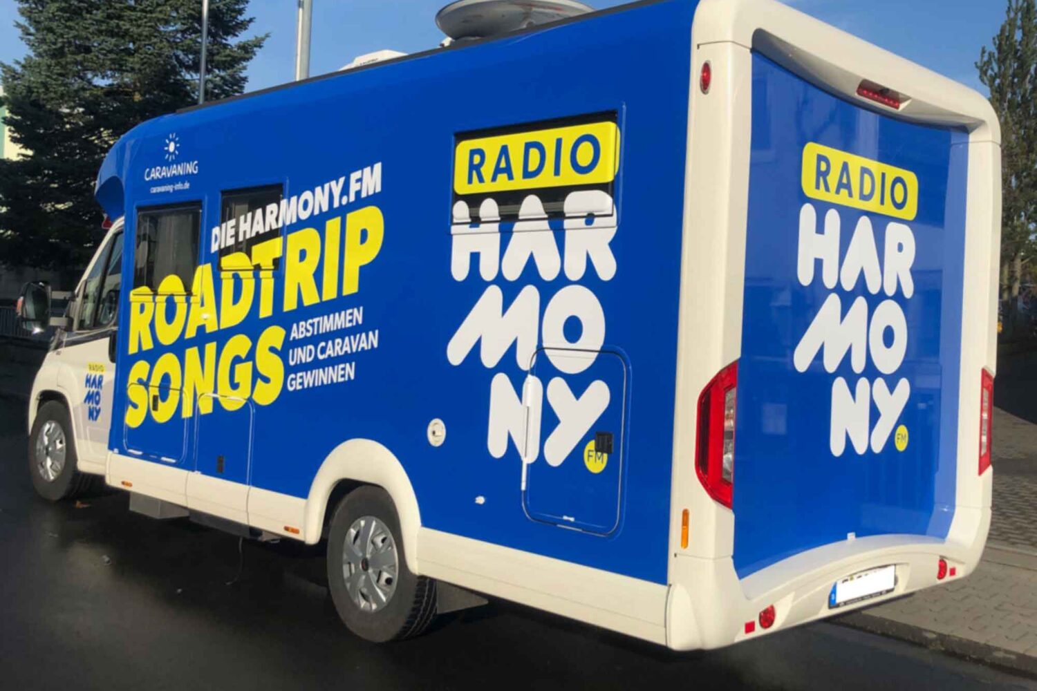 Vollverklebung-Harmony2 Fahrzeugbeschriftung für Harmonie FM Vollverklebung in Blau mit Plotts Auto vor unserer Halle in Dietzenbach