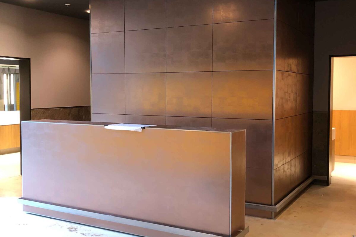 3M-Dinoc-Möbelfolie-in-Kupfer-auf-Empfangstresen-und-Wandfläche